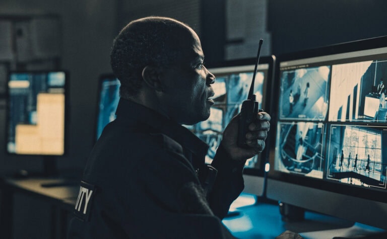 Security officer monitoring cameras with AI